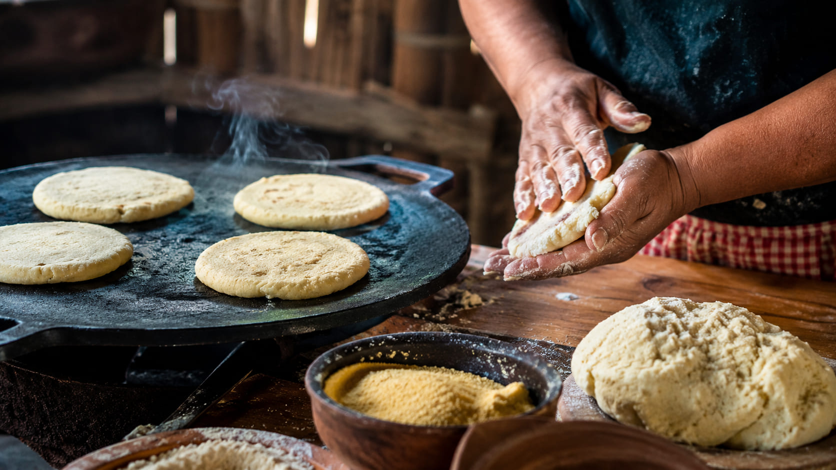 Masa de arepas venezolanas sobre budare caliente